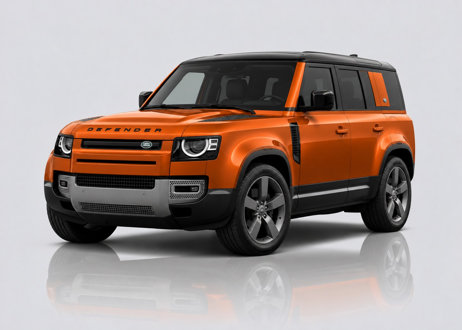 Orange Land Rover Defender in a light grey studio
